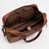 Brown leather bag with open interior on a white background
