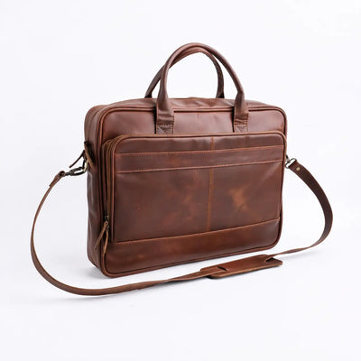 Brown leather bag with shoulder strap on a white background
