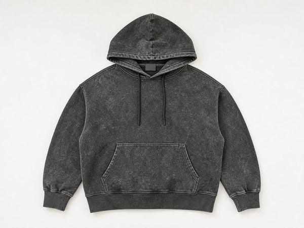 Custom acid-wash hoodie in mottled charcoal heavyweight fleece, front flat lay — custom manufacturing by DenimByte