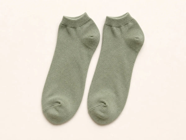 Photorealistic product mockup of a matching pair of blank sage cotton ankle socks with reinforced heels and toes.