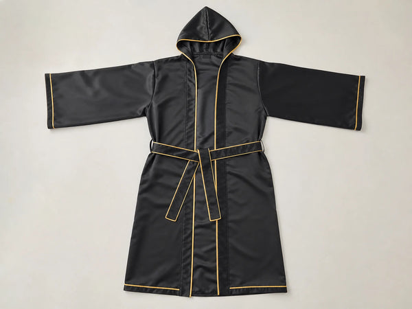 Custom black satin boxing walkout robe with gold piping, front flat lay