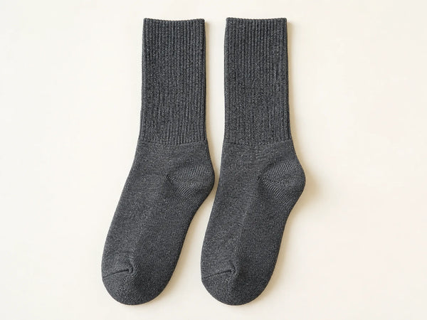 Photorealistic product mockup of a matching pair of blank charcoal heather cushioned crew socks viewed overhead.