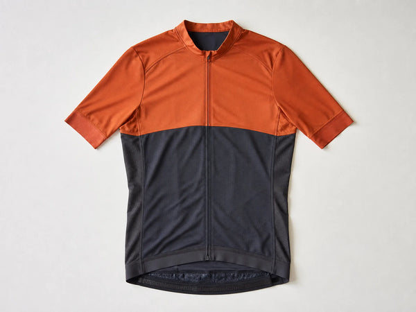 Custom orange and charcoal short-sleeve cycling jersey, front flat lay
