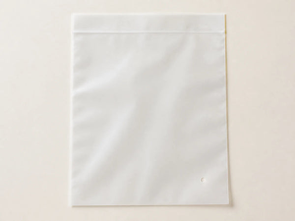 Photorealistic product mockup of a blank frosted recyclable garment polybag with a self-seal flap viewed overhead.