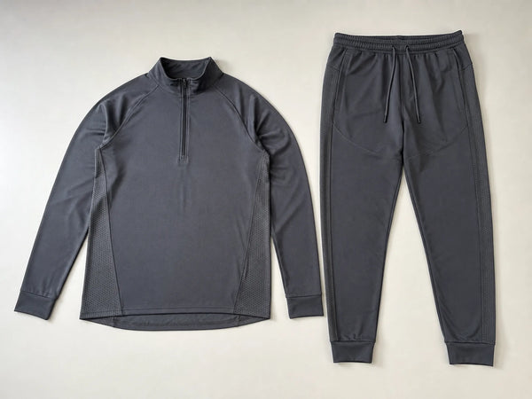 Custom graphite performance training tracksuit with technical top and pants, front flat lay