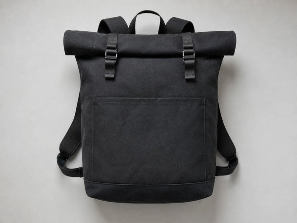 Photorealistic product mockup of a blank black waxed-canvas roll-top backpack with matte buckles viewed overhead.