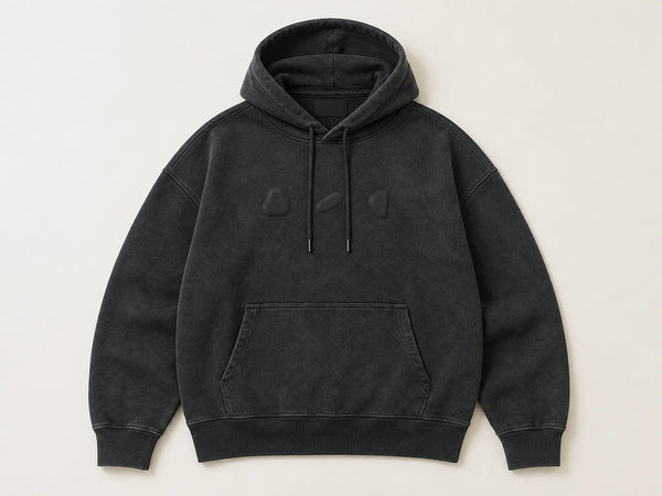 Custom streetwear hoodie in washed black with tonal puff print, front flat lay