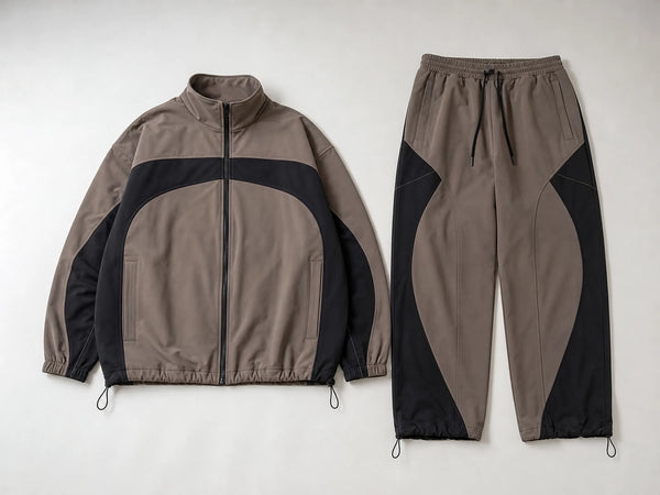 Custom taupe and black streetwear tracksuit with panelled jacket and pants, front flat lay