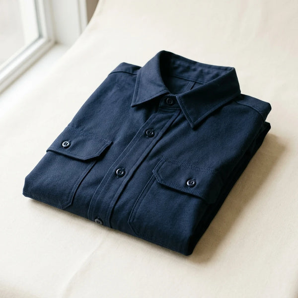 Folded navy twill custom work shirt sample with chest pockets — uniform and workwear sampling by DenimByte